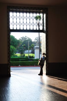 Acoustic guitar player stands in a bright tile doorway at Union Station