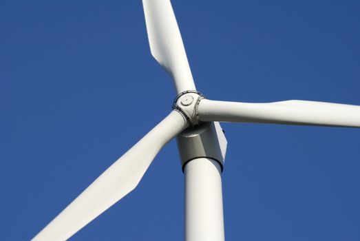 Close-up of wind turbine against blue sky