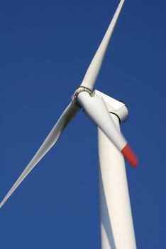 Close-up of wind turbine against blue sky