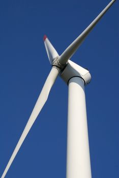 Close-up of wind turbine against blue sky