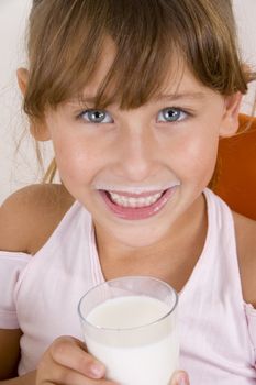 smiling girl with glass of milk looking at the camera