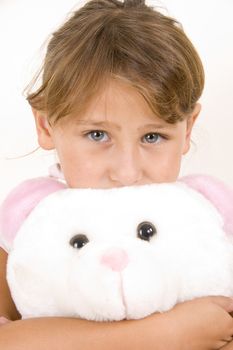 little girl with teddy bear looking you