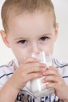 little child drinking milk in glass
