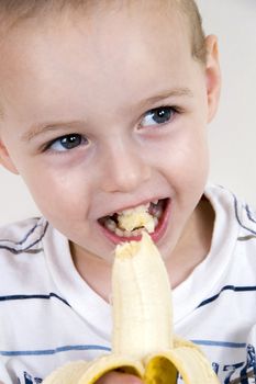 close up of healthy boy eating banana