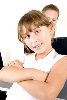 beautiful girl looking to camera and her mother working on laptop