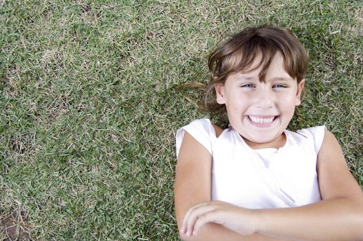 smiling young cute girl lying on the grass