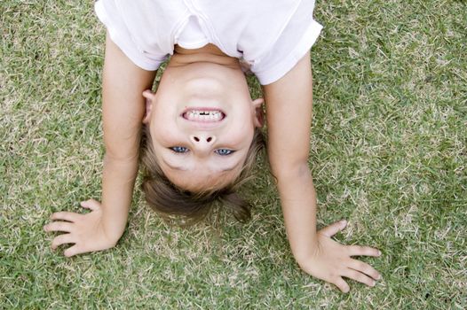 young girl doing cartwheel on the grass