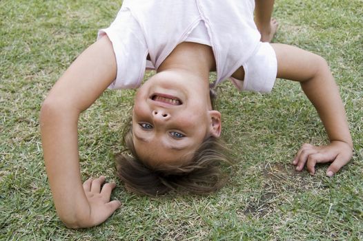 young girl doing cartwheel on the grass