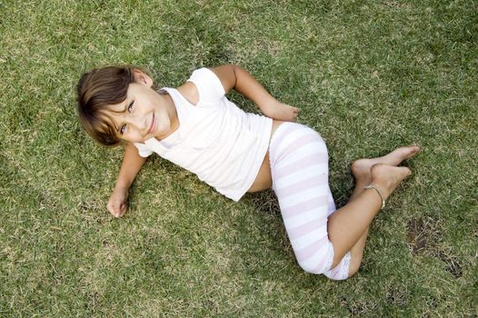 smiling young cute girl lying on the grass