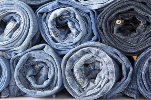roll blue denim jeans arranged in stack