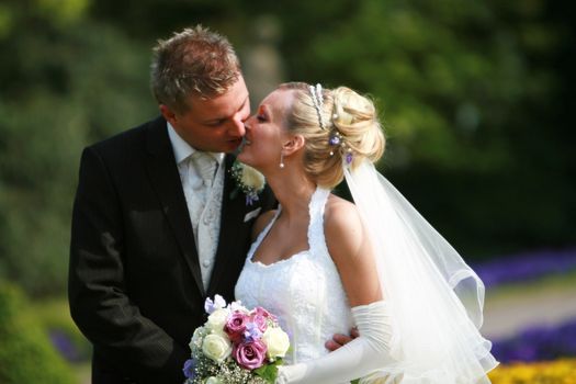 Young couple -  bride and bridegroom - kissing - outside