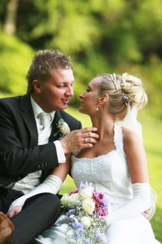  bride and bridegroom , young couple kissing - outside