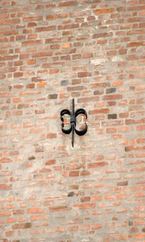 Cast iron fixture on sunlit brick wall.
