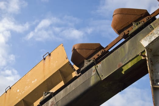 part of a conveyor against a cloudy sky