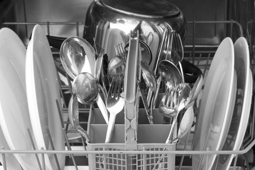 dinnerware and cutlery inside a dishwasher
