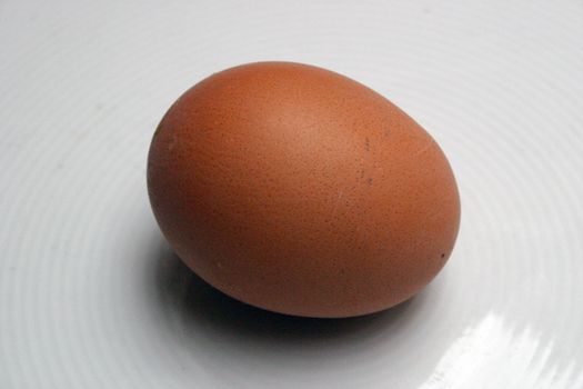 brwon egg with detailed eggshell on a white dish