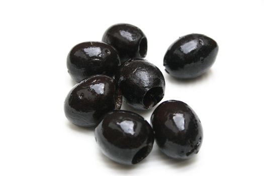 close up of seven olives on white background