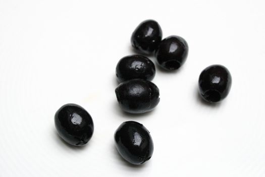 seven fresh olives on a white background