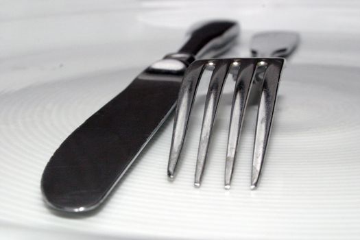 A fork and a knife on white dish