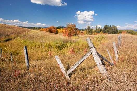 Beautiful Fall Landscape with Rustic Fence and Clouds