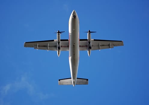Aircraft flying directly above with a blue sky as a background