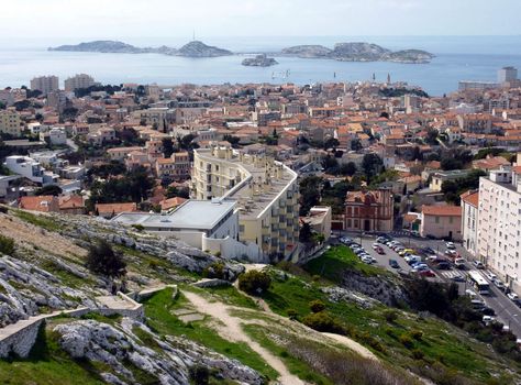 View of Marseilles city with lots of red roofs and Frioul islands in mediterranean sea further, France