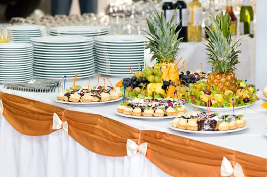 served banquet dessert table, sliced fruits, cakes