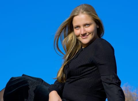 Portrait of the beautiful young girl against blue sky