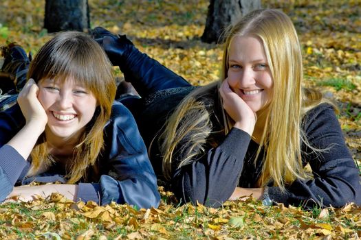 Two girlfriends against the autumn nature