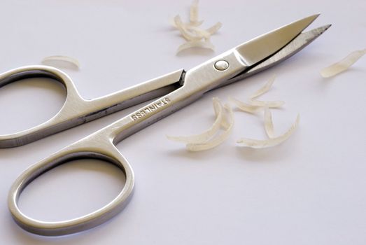 a pair of toe nail scissors on some nail clippings