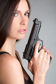 Sexy brunette woman holding gun