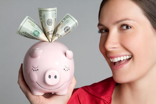 Woman holding piggy bank with money