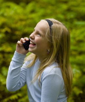 A happy girl on a cell phone outdoors