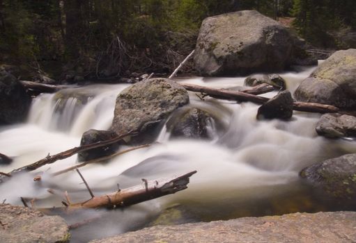 Fast spring water in an impressionistic image of the St. Vrain river in Rocky Mountain National Park