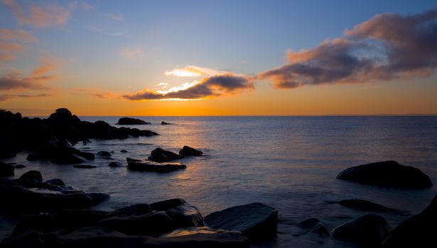 Superior sunbeam from cloud to water to stone at Brighton Beach in Duluth, Minnesota.