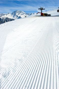 Snowcat track close-up with Snowcat at background