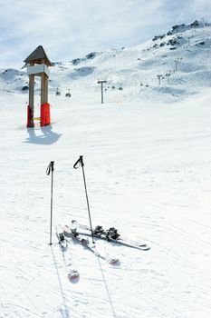 Blank signpost and skis on piste at ski resort