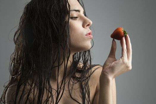 Topless caucasian woman holding strawberry.