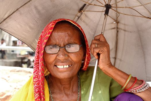 Old woman with umbrela - India