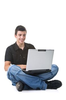 Young man sitting on the floor using a laptop. Isolated on white background.