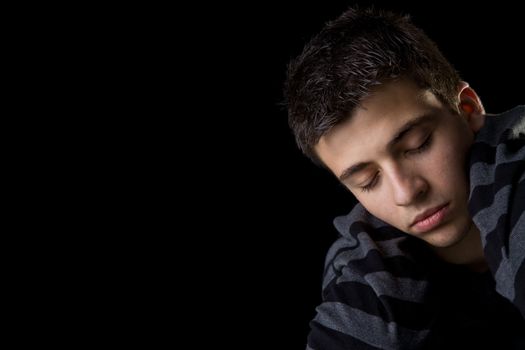 Moody portrait of a handsome young man, looking tired and serene.