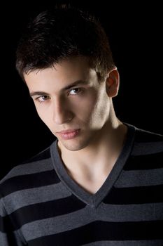 Portrait of a handsome young man isolated on black background.