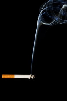 a smoking cigarette in front of black background