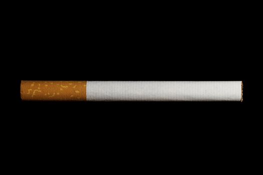 one cigarette with filter isolated on black background