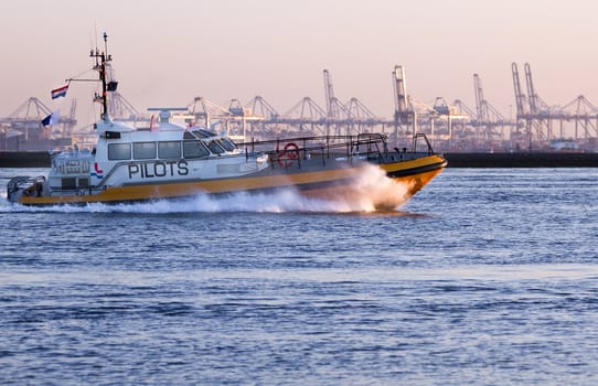 Pilot-boat passing by at high speed on the river in evening light - industry background