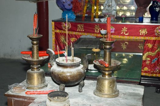 China, Nantong city, Jiangsu province. Traditional temple, indoor photo showing altar with candles, incenses from prayers. 