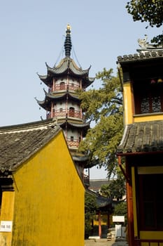 Traditional Chinese temple in Nantong city, Jiangsu province, China. Temple consists of few buildings, tower, monk's hostel and fireplace for incense. 