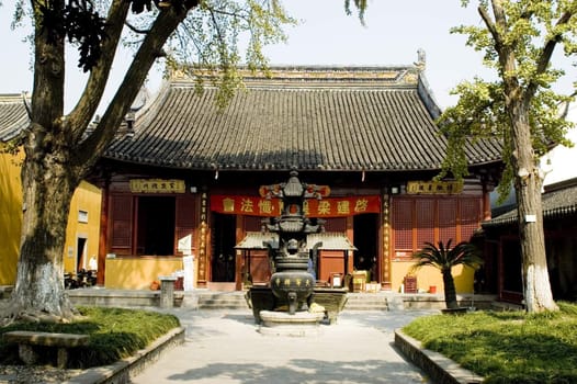 Traditional Chinese temple in Nantong city, Jiangsu province, China. Temple consists of few buildings, tower, monk's hostel and fireplace for incense. 