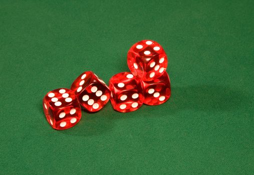 Red dices on the green table in the casino