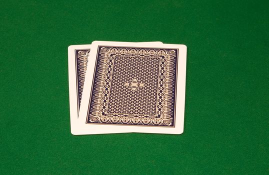 Two cards with faces down on the green table